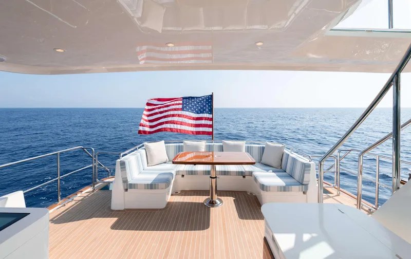 Slide: The Image of The 2020 Hunt Yachts Ocean 63 Flybridge features a spacious deck with seating area and table. - 12