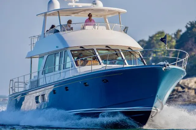 Slide: The Image of Hunt Yachts Ocean 63 Flybridge from 2020 on the water with people on the upper deck. - 3