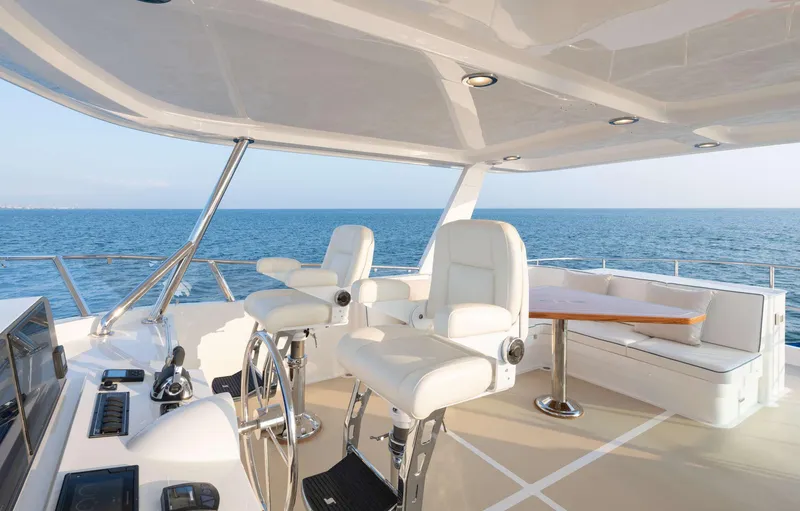 Slide: The Image of Flybridge of the 2020 Hunt Yachts Ocean 63 with white seating and ocean view. - 7