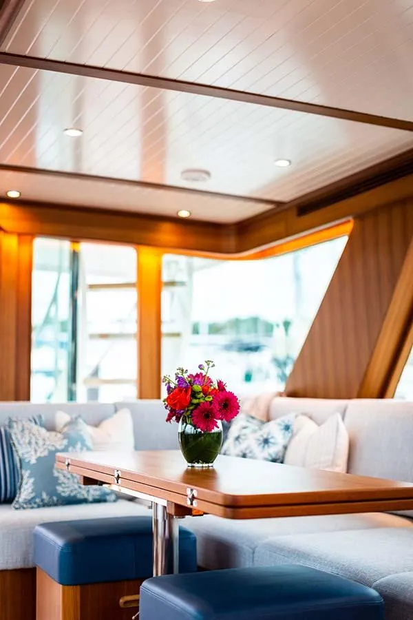 Slide: The Image of Interior of the 2020 Hunt Yachts Ocean 63 Flybridge with elegant seating and a floral arrangement. - 25