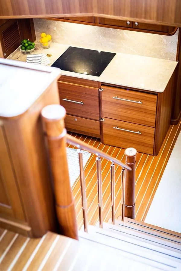 Slide: The Image of The 2020 Hunt Yachts Ocean 63 Flybridge kitchen features wooden cabinets and a stovetop. - 43