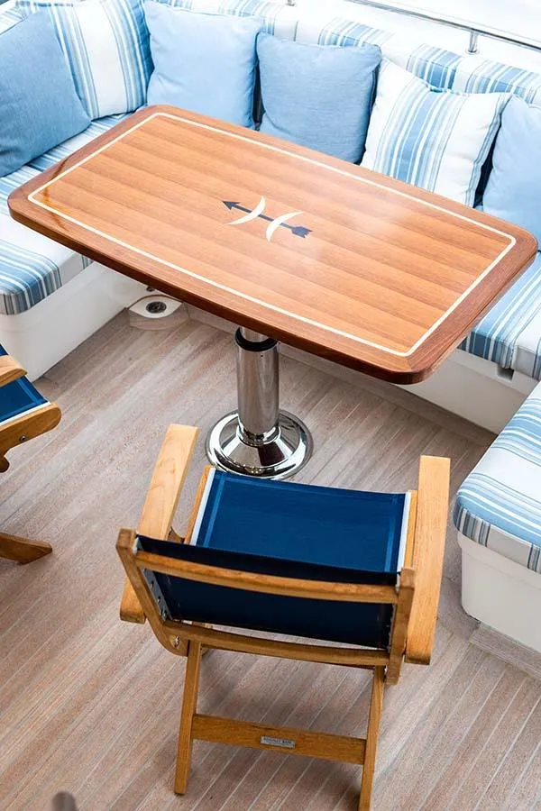 Slide: The Image of A sleek wooden table with a nautical design, surrounded by blue and striped cushions. - 20