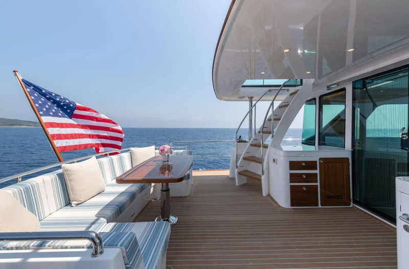 Slide: The Image of The 2020 Hunt Yachts Ocean 63 Flybridge features an elegant aft deck with seating and a table. - 14