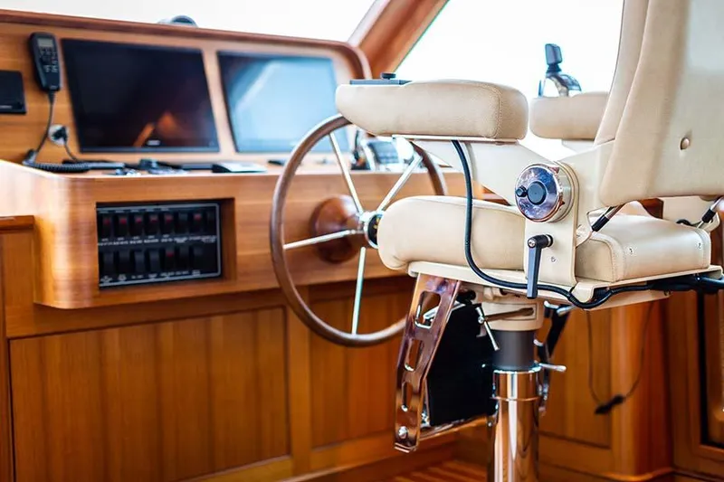 Slide: The Image of The cockpit of the 2020 Hunt Yachts Ocean 63 Flybridge with a sleek steering wheel and comfortable captain's chair. - 33