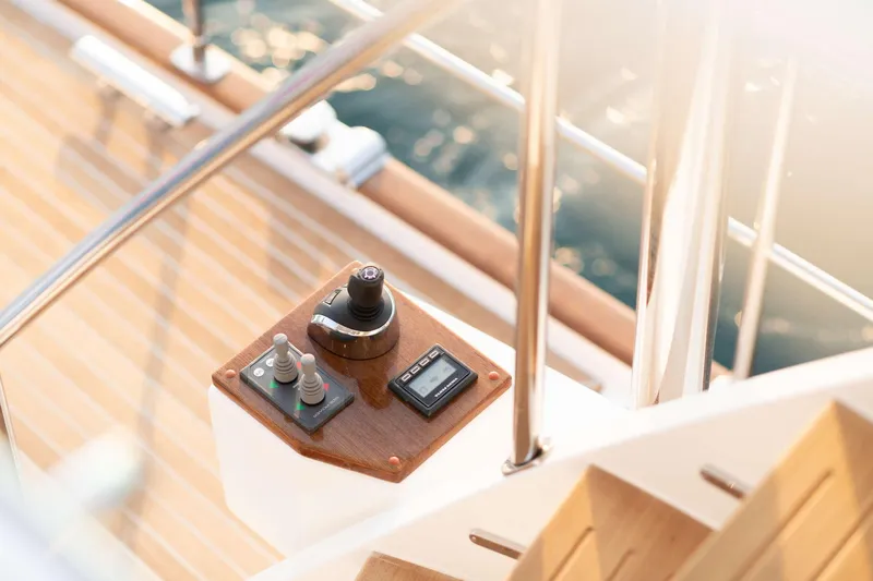 Slide: The Image of Helm station on the flybridge with wood details and a view of the water. - 11