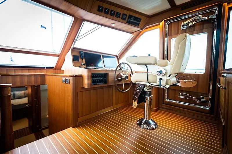 Slide: The Image of Interior of the 2020 Hunt Yachts Ocean 63 Flybridge with elegant wood paneling and steering wheel. - 38