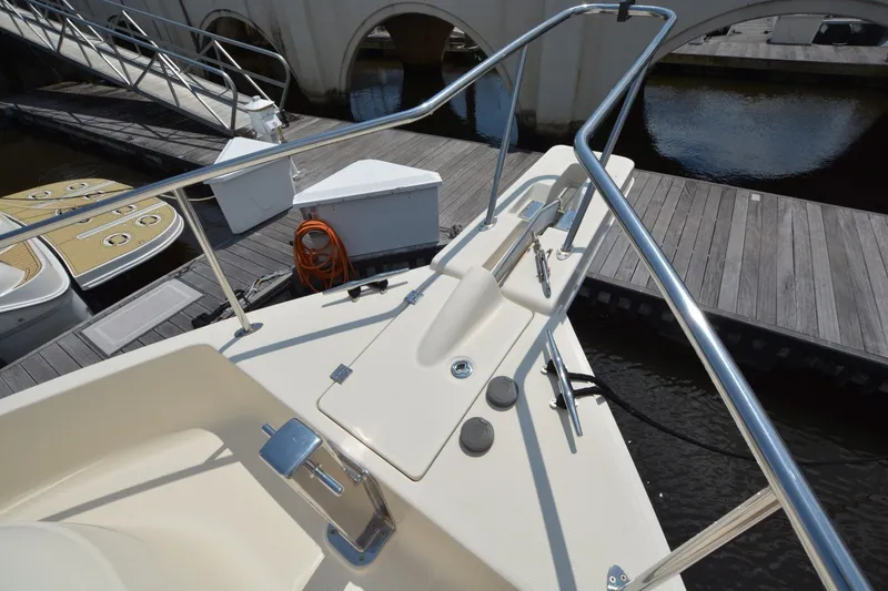 Slide: The Image of 2005 Mainship 34 Trawler bow with stainless steel railings at marina dock. - 3