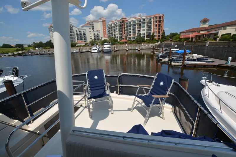 Slide: The Image of 2005 Mainship 34 Trawler deck with chairs, overlooking marina and waterfront buildings. - 10