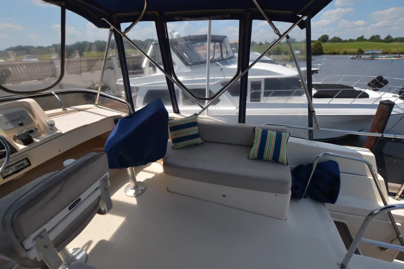 Slide: The Image of 2005 Mainship 34 Trawler interior with seating, helm, and marina view. - 9
