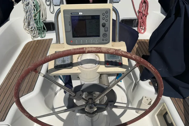 Slide: The Image of The cockpit of a 2009 Beneteau Oceanis 31 features a steering wheel and navigation instruments. - 8