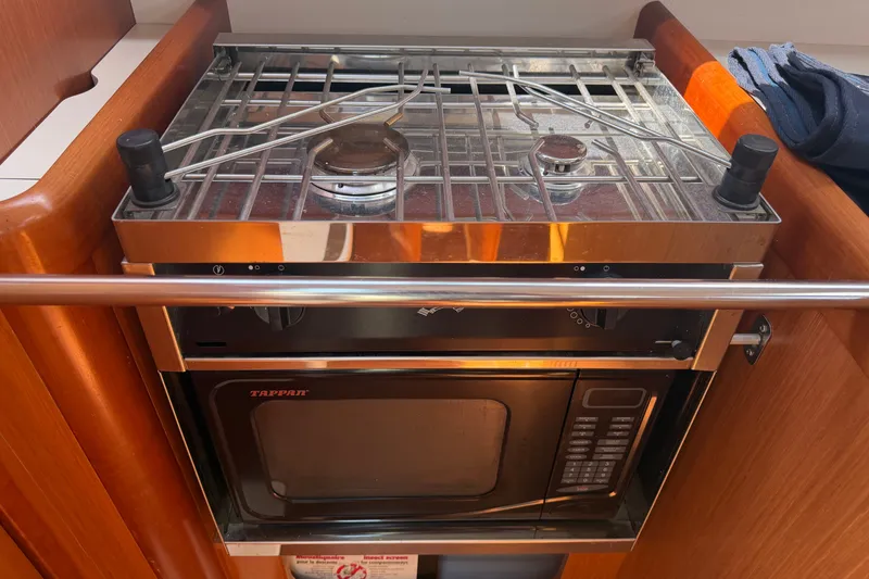 Slide: The Image of Compact kitchen setup on a 2009 Beneteau Oceanis 31 yacht, featuring a stove and microwave. - 46