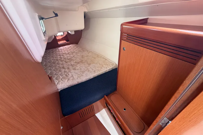 Slide: The Image of Interior cabin of 2009 Beneteau Oceanis 31 sailboat with cozy bed and wooden cabinetry. - 36
