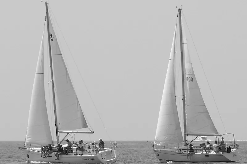 Slide: The Image of Two Beneteau Oceanis 31 sailboats from 2009 sailing side by side on calm waters. - 4