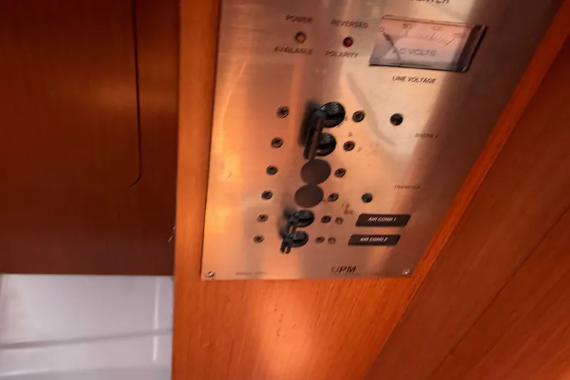 Slide: The Image of Control panel inside a 2009 Beneteau Oceanis 31 sailboat, featuring switches and voltage meter. - 51
