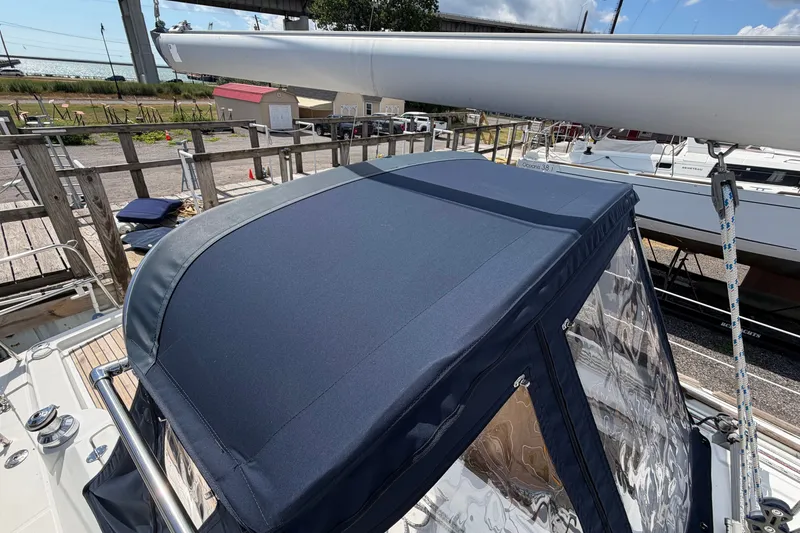 Slide: The Image of 2009 Beneteau Oceanis 31 sailboat with blue canvas cover, docked outdoors. - 11