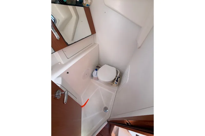 Slide: The Image of Compact bathroom in 2009 Beneteau Oceanis 31 sailboat, featuring a toilet and mirror. - 44