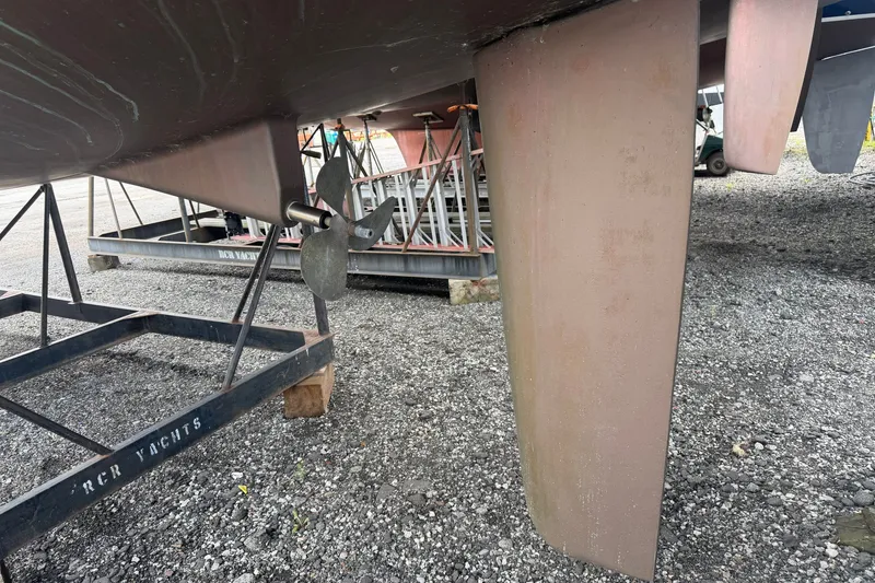 Slide: The Image of 2009 Beneteau Oceanis 31 sailboat keel and propeller on a gravel surface. - 56