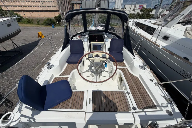 Slide: The Image of Cockpit view of 2009 Beneteau Oceanis 31 sailboat with wooden deck and blue seating. - 12