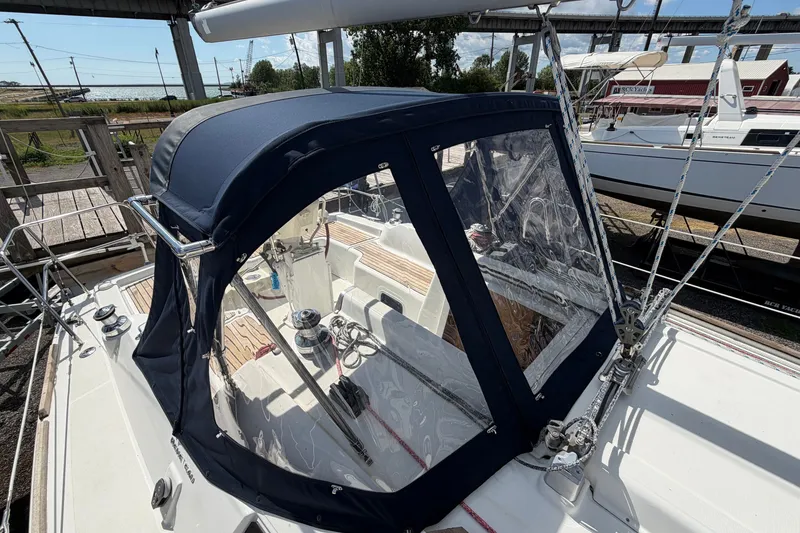 Slide: The Image of 2009 Beneteau Oceanis 31 sailboat with blue cockpit cover, docked at marina. - 13