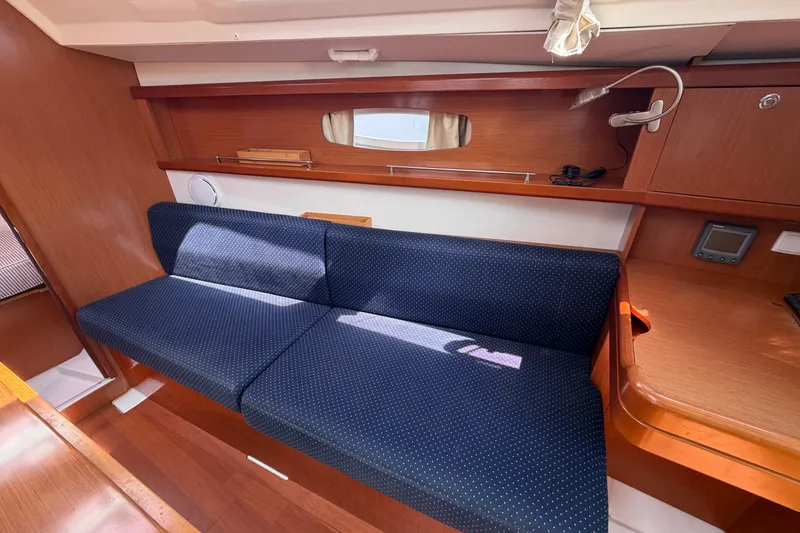 Slide: The Image of Interior of 2009 Beneteau Oceanis 31 yacht with blue cushioned seating and wooden finish. - 25