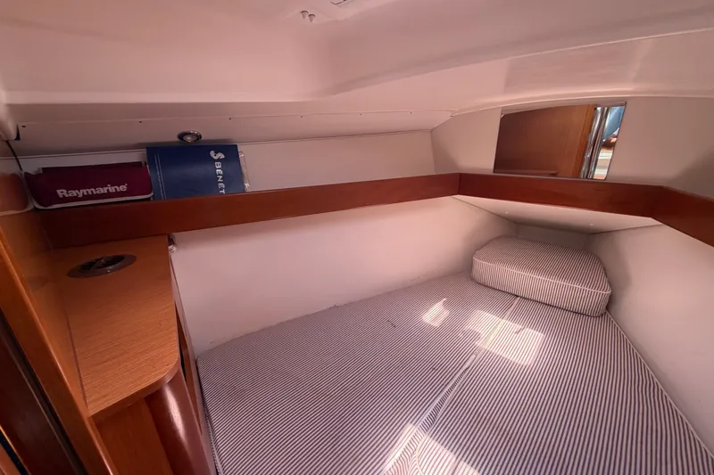 Slide: The Image of Cozy cabin interior of 2009 Beneteau Oceanis 31 sailboat with striped bedding. - 32