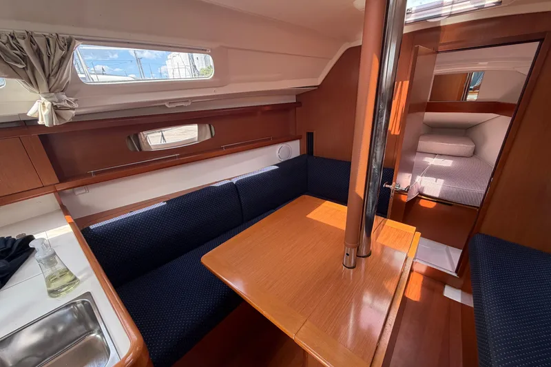 Slide: The Image of Interior of 2009 Beneteau Oceanis 31 sailboat with cozy seating and wooden table. - 26