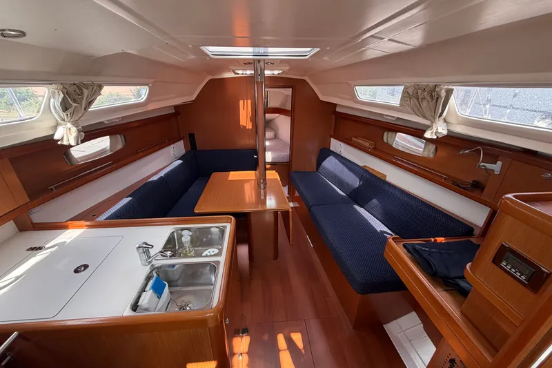 Slide: The Image of Interior of 2009 Beneteau Oceanis 31 sailboat with cozy seating and compact kitchen area. - 22