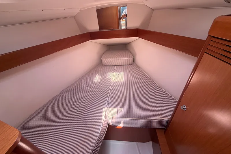 Slide: The Image of Cozy cabin interior of 2009 Beneteau Oceanis 31 sailboat with striped bedding. - 33