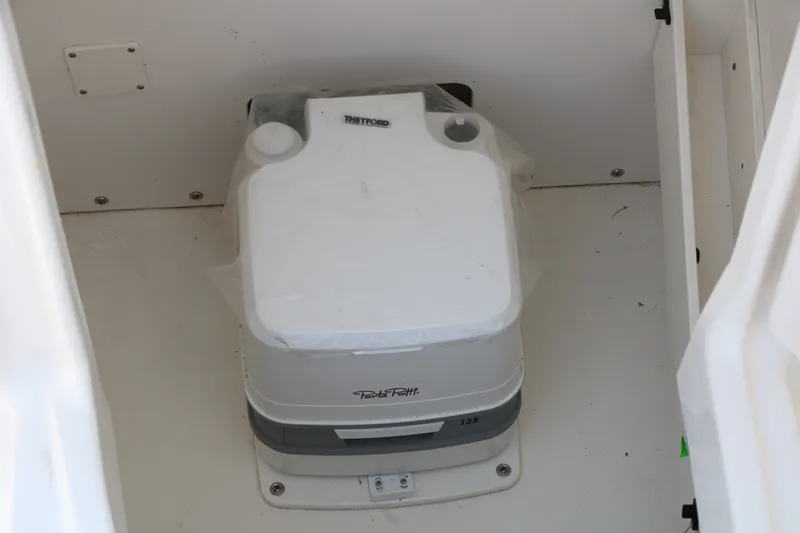 Slide: The Image of Portable toilet inside 2026 Robalo R230 Center Console boat. - 23