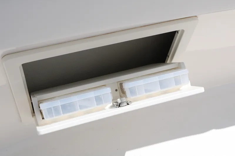 Slide: The Image of Storage compartment on 2026 Robalo R230 Center Console boat, featuring organized tackle boxes. - 21
