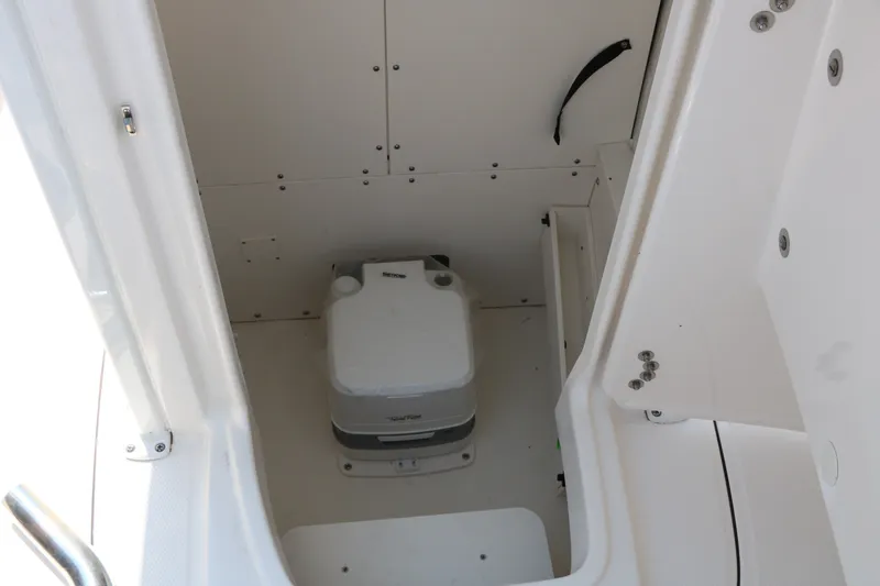 Slide: The Image of 2026 Robalo R230 Center Console boat interior with compact marine toilet. - 22
