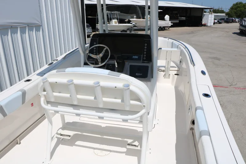 Slide: The Image of 2026 Robalo R230 Center Console boat interior with steering wheel and rod holders. - 13