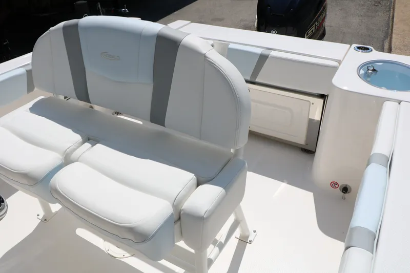 Slide: The Image of 2026 Robalo R230 Center Console boat interior with cushioned seating and storage. - 26