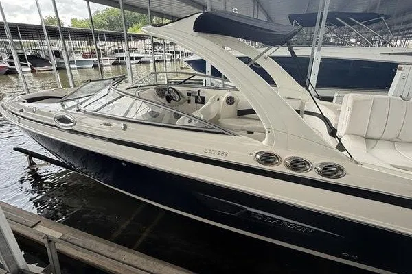 The Image of 2010 Larson LXi 288 boat docked in marina, featuring sleek design and spacious seating. - 1