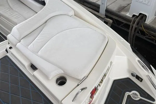 Slide: The Image of White seating area on a 2010 Larson LXi 288 boat, featuring cup holders and sleek design. - 14