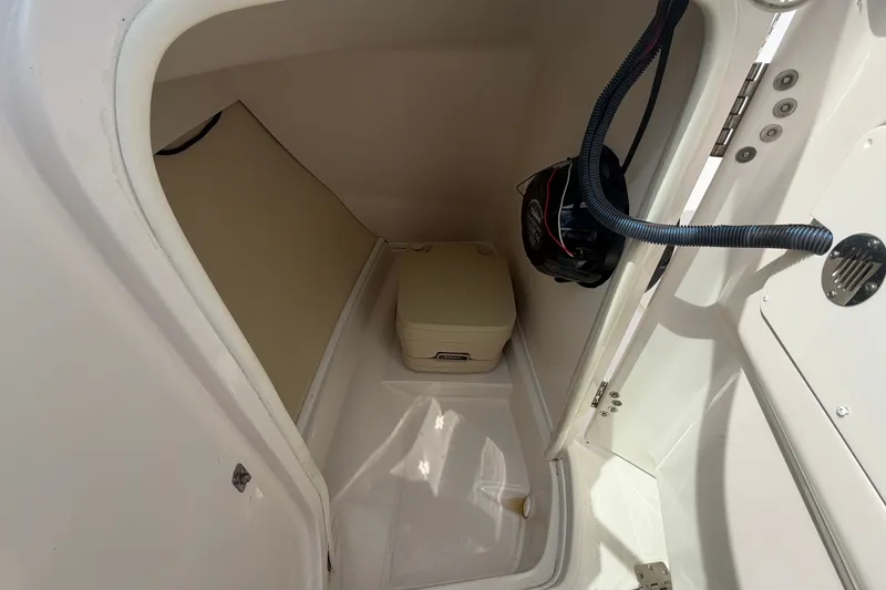Slide: The Image of 2009 Monterey 234FS boat interior storage compartment with portable toilet and life jacket. - 21