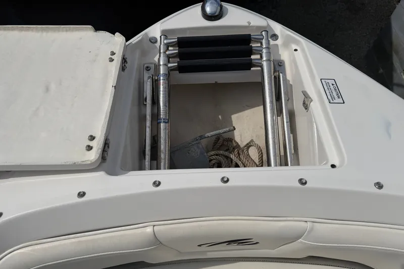 Slide: The Image of An open storage compartment on a 2009 Monterey 234FS boat with a ladder and ropes. - 19