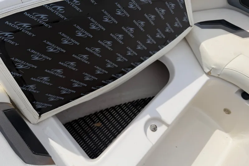 Slide: The Image of Open storage compartment on a 2009 Monterey 234FS boat with branded interior lining. - 24