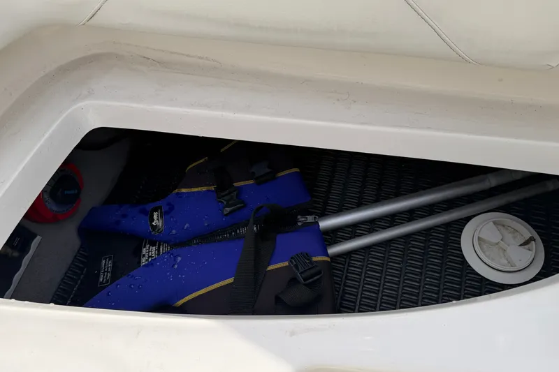 Slide: The Image of A blue life jacket and paddles in a storage compartment of a boat. - 31