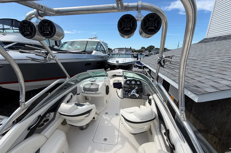 Slide: The Image of 2009 Monterey 234FS boat interior with speakers and seating, docked alongside other boats. - 15