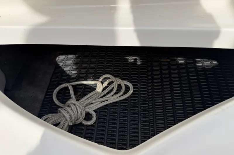 Slide: The Image of Coiled rope on black mat inside 2009 Monterey 234FS boat compartment. - 29