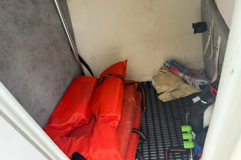 Slide: The Image of Storage compartment of a 2009 Monterey 234FS boat with life jackets and supplies. - 20