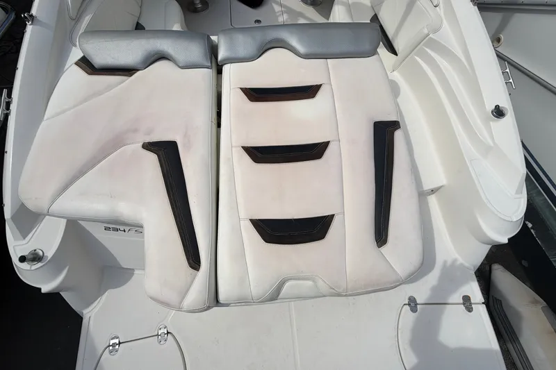 Slide: The Image of The image shows the rear seats of a 2009 Monterey 234FS boat with white upholstery. - 14