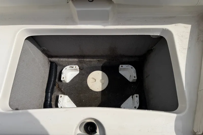 Slide: The Image of An open storage compartment on a 2009 Monterey 234FS boat, featuring a gray interior and black floor. - 30