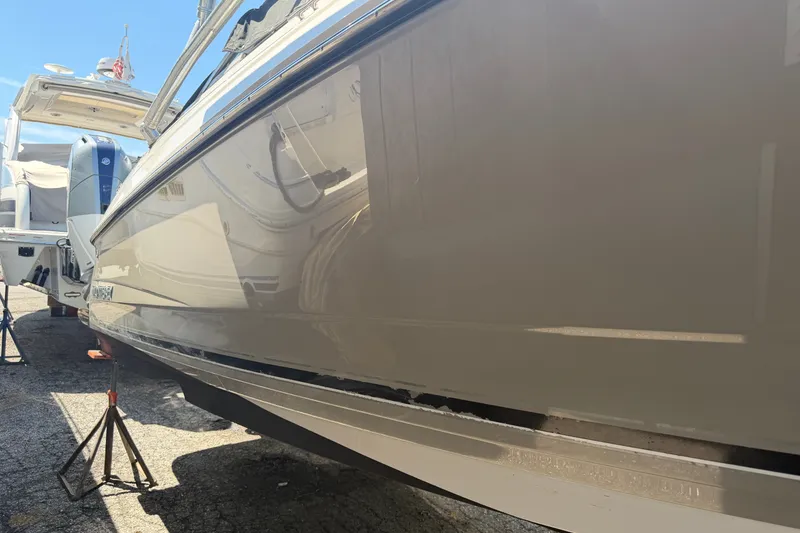 Slide: The Image of 2009 Monterey 234FS boat on stands, side view, in a sunny outdoor setting. - 36