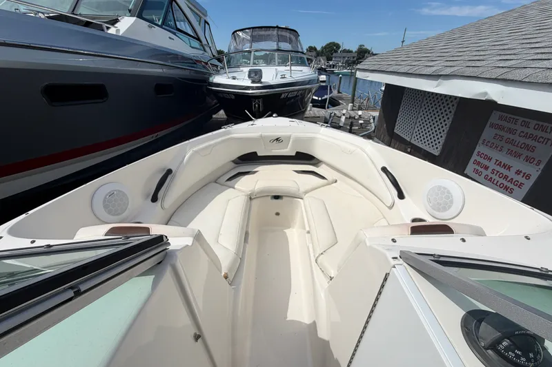 Slide: The Image of 2009 Monterey 234FS boat interior with seating, docked between other boats. - 23