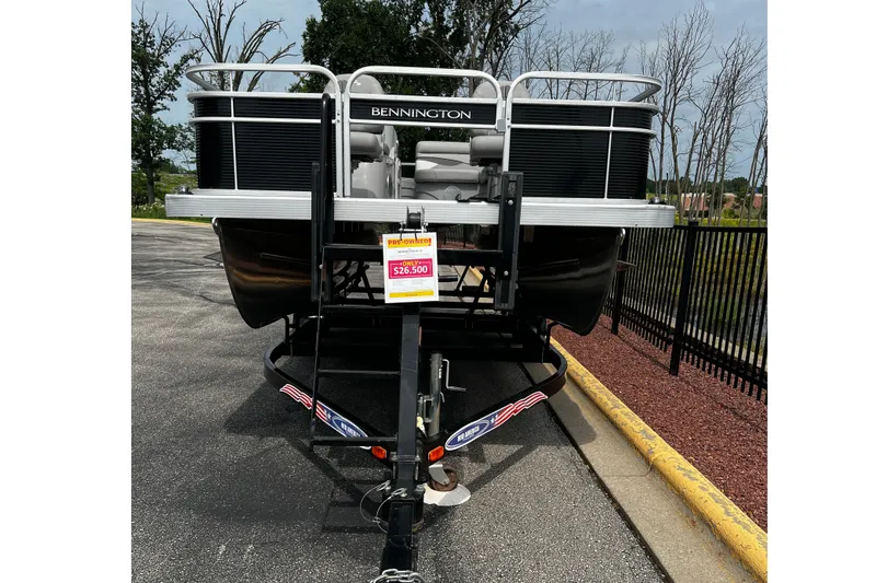 Slide: The Image of 2023 Bennington 20 SF pontoon boat on trailer, priced at $26,500, displayed outdoors. - 2