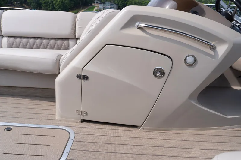 Slide: The Image of 2017 Bennington R25 boat interior with beige seating and storage compartment. - 19