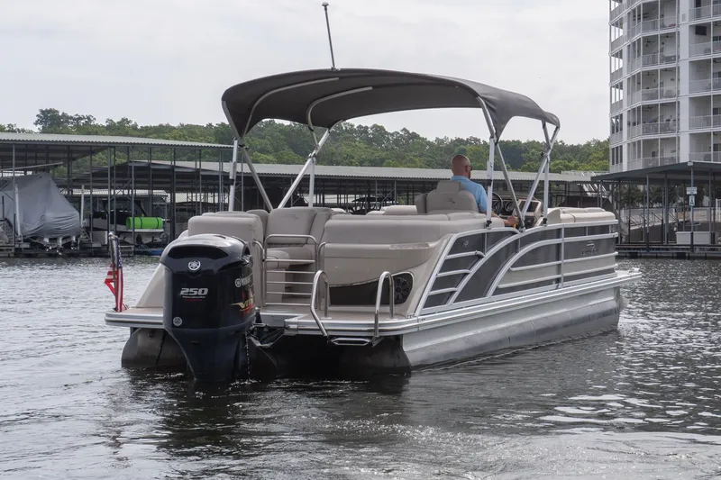 Slide: The Image of 2017 Bennington R25 pontoon boat on water near marina and buildings. - 4