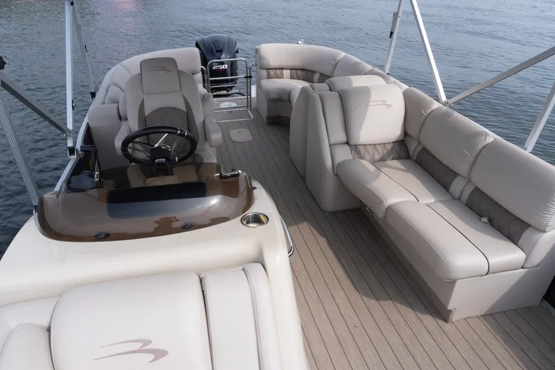 Slide: The Image of Luxurious 2017 Bennington R25 pontoon boat interior with plush seating and steering console. - 16